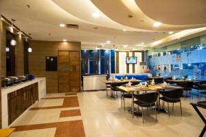 a restaurant with tables and chairs and a bar at Hyphen Premier-Business Hotel in Meerut