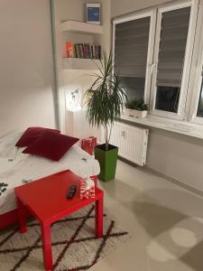 AS Apartment Lodz في لودز: غرفة نوم بسرير وطاولة قهوة حمراء