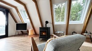 a living room with a fireplace and a tv at Design Chalet Vulkaneifel in Kerschenbach