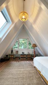 an attic bedroom with a bed and a chandelier at Design Chalet Vulkaneifel in Kerschenbach