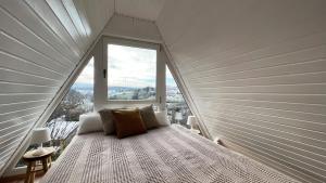 a bed in a room with a large window at Design Chalet Vulkaneifel in Kerschenbach
