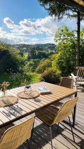 a wooden table and chairs on a wooden deck at Design Chalet Vulkaneifel in Kerschenbach