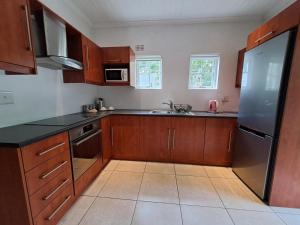 una cucina con armadi in legno e frigorifero in acciaio inossidabile di Fiore Guest Accommodation a Greyton