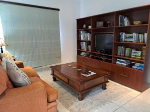 a living room with a couch and a tv and a coffee table at Fiore Guest Accommodation in Greyton