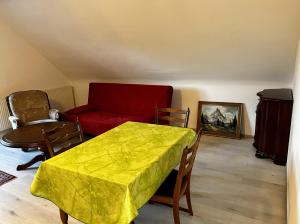a living room with a table and a red couch at Ferienwohnung mit Balkon - 3 Zimmer in Wedemark