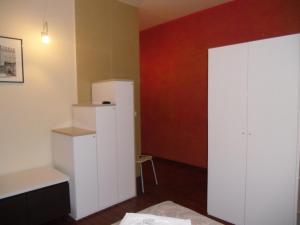 um quarto com um armário branco e uma parede vermelha em Scendi dal treno em Bolonha