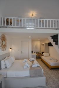 a living room with a large bed and a staircase at Aspro Phos Santorini Hotel in Perissa