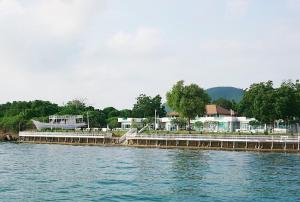 a dock on a body of water with houses at Rimtalay Resort Koh Larn in Ko Larn