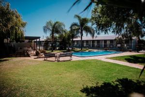 een park met banken en een zwembad bij Kalgoorlie Overland Motel in Kalgoorlie
