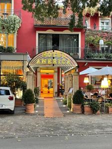 un restaurant avec une porte jaune vif devant un bâtiment dans l'établissement Hotel America, à Trente