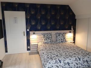 1 dormitorio con 1 cama grande y pared azul en La Clémencerie Chambre d'hôtes en LʼÉtang-la-Ville