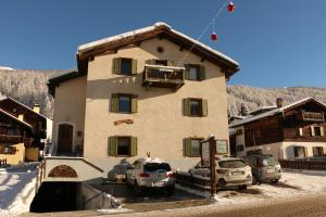 a large house with cars parked in front of it at Bait da Sandro in Livigno
