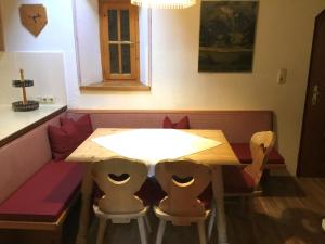 een houten tafel met twee stoelen eromheen bij Apartment Burg Biedenegg- Niedermontani - FIE204 by Interhome in Fliess