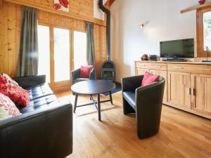 sala de estar con sofá, sillas y mesa en Apartment Grives by Interhome, en Les Collons