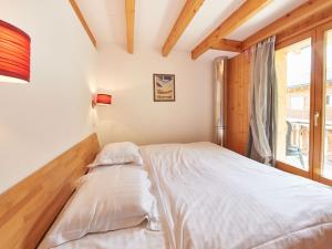 Cama en habitación con ventana en Apartment Grives by Interhome, en Les Collons