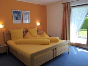 een slaapkamer met een bed met gele kussens en een raam bij Apartment Christina - IST400 by Interhome in Tarrenz