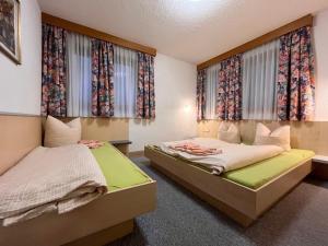 2 camas en una habitación pequeña con ventanas en Apartment Appartment Wildmoos - SOE316 by Interhome, en Sölden