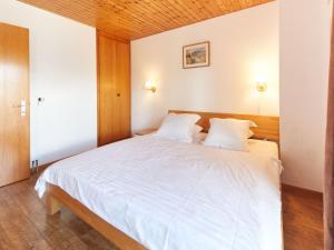1 dormitorio con 1 cama blanca grande y 2 almohadas en Chalet Genepi by Interhome, en Les Collons
