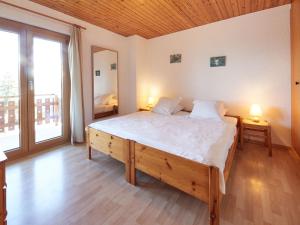 a bedroom with a large bed and a large window at Chalet Basilic by Interhome in Les Collons