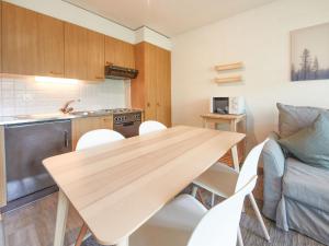 a kitchen and dining room with a wooden table and chairs at Apartment Hameau D004 by Interhome in Les Collons