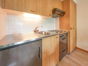 a kitchen with a sink and a stainless steel appliance at Apartment Hameau D004 by Interhome in Les Collons