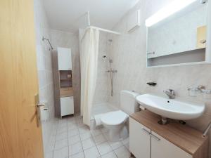 a white bathroom with a sink and a toilet at Apartment Sérandes 2 by Interhome in Les Collons