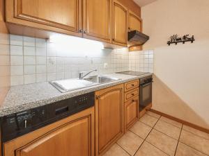 uma cozinha com armários de madeira e um lavatório em Apartment Sérandes 9 by Interhome em Les Collons