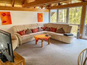 a living room with a couch and a tv at Chalet Christine by Interhome in Molberting