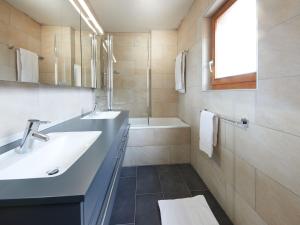 a bathroom with two sinks and a shower and a tub at Chalet Hiboux by Interhome in Les Collons