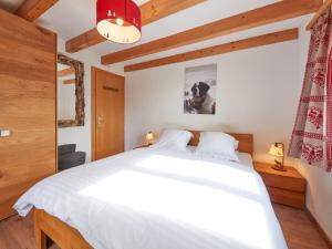 レ・コロンにあるChalet Hiboux by Interhomeの木製の天井、大きな白いベッドが備わるベッドルーム1室が備わります。