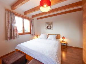 a bedroom with a large white bed and a window at Chalet Hiboux by Interhome in Les Collons