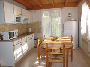 eine Küche mit einem Holztisch und einem weißen Kühlschrank in der Unterkunft Holiday Home Les Etrilles by Interhome in La Tranche-sur-Mer