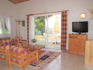 a living room with a couch and a tv at Holiday Home Les Etrilles by Interhome in La Tranche-sur-Mer +13 photos