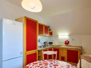uma cozinha com armários vermelhos e um frigorífico branco em Apartment Klondajk - HRA120 by Interhome em Harrachov