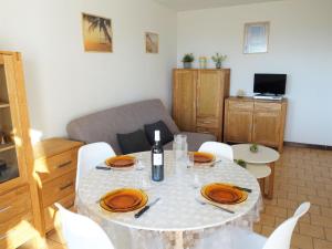 a living room with a table with a bottle of wine at Apartment Les Balcons de la Méditerranée-2 by Interhome in Narbonne-Plage