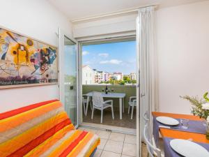 Habitación con cama y balcón con mesa. en Apartment Robinia-Pinetine-3 by Interhome, en Duna Verde
