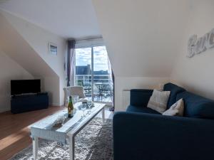 uma sala de estar com um sofá azul e uma mesa em Apartment Marjolaine - PFE104 by Interhome em Pléneuf-Val-André