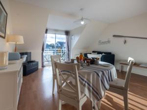 uma cozinha e sala de jantar com mesa e cadeiras em Apartment Marjolaine - PFE104 by Interhome em Pléneuf-Val-André