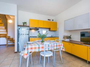 ドゥナ・ヴェルデにあるApartment Robinia-Pinetine-4 by Interhomeのキッチン(テーブル、椅子、黄色のキャビネット付)