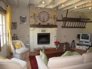 a living room with a fireplace and a clock on the wall at Holiday Home La Janverie - MNX200 by Interhome in Monteaux