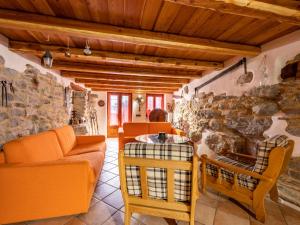a living room with orange furniture and a stone wall at Holiday Home Casa Ivan by Interhome in Noasca
