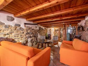 a living room with two couches and a stone wall at Holiday Home Casa Ivan by Interhome in Noasca