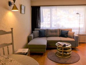 a living room with a couch and a window at Apartment Milihaus A by Interhome in Zermatt