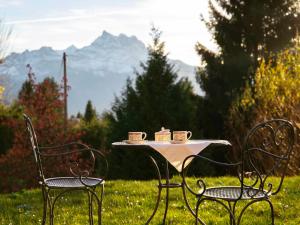 Chalet Chalet Petit Pont by Interhome في فيلار سور أولون: كرسيين وطاولة عليها أكواب الشاي