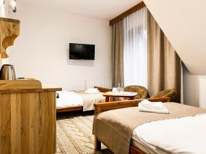 a hotel room with two beds and a tv at Bacówka Biały Jeleń in Iwkowa +55 photos