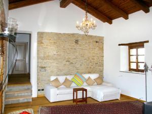 sala de estar con sofá blanco y pared de ladrillo en Apartment Girasole - MZO105 by Interhome, en Belvedere Langhe