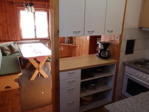 a small kitchen with a desk and a table at Apartment Montana by Interhome in Langwies +21 photos