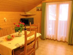 a dining room with a table with flowers on it at Apartment Lärchenheim by Interhome in Gasenried