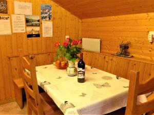 a table with a bottle of wine and flowers on it at Apartment Lärchenheim by Interhome in Gasenried