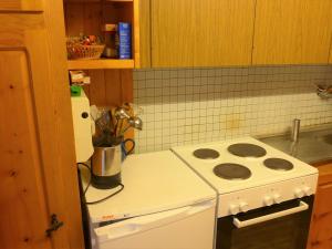 a kitchen with a white stove and a refrigerator at Apartment Lärchenheim by Interhome in Gasenried